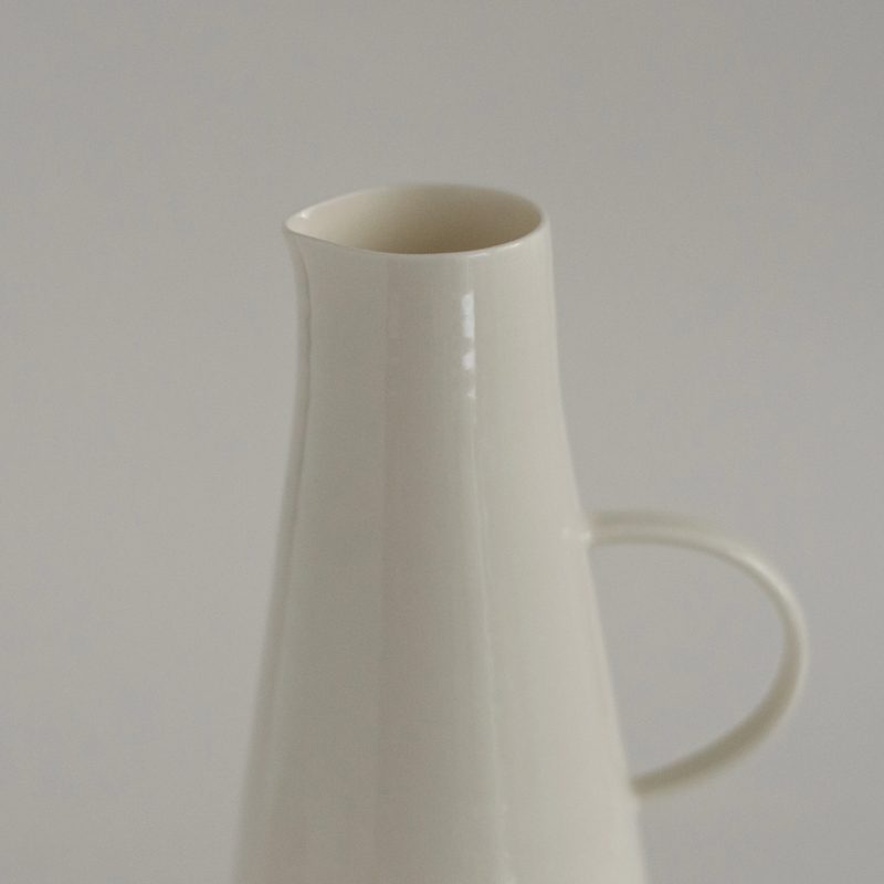 A single tall porcelain jug on a pale ground