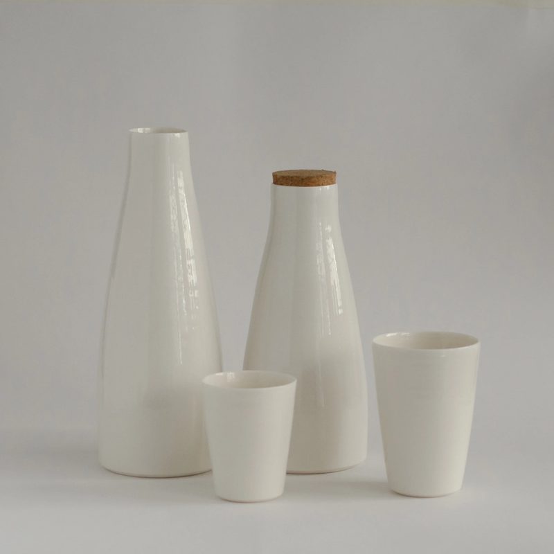 A porcelain jug, beaker and vase in a bright still life