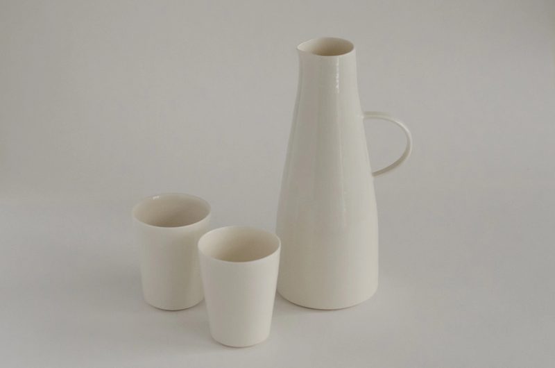 A tall porcelain jug with two beakers