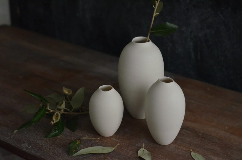 A pair of small porcelain vases with an olive sprig