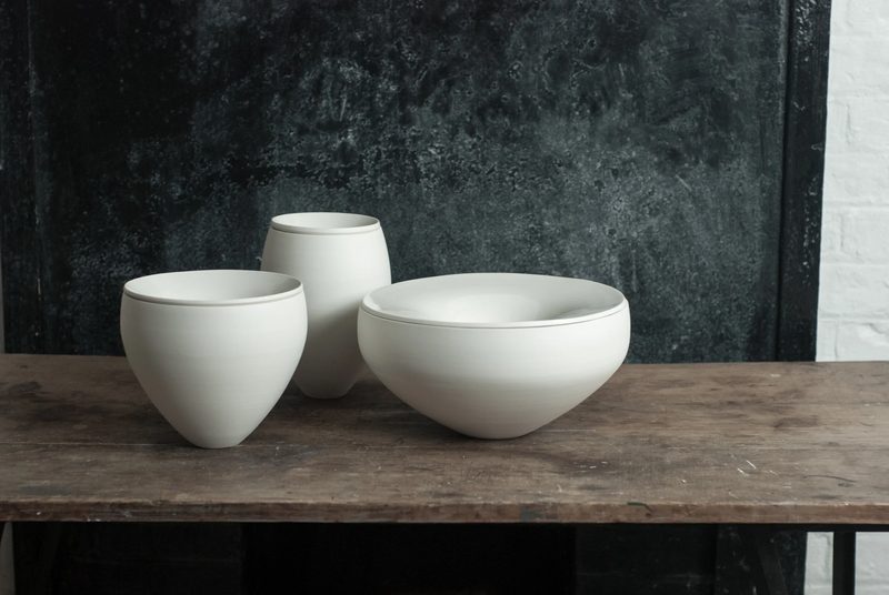 A pair of porcelain bowls, one with a dark glazed interior
