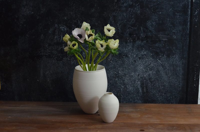A small porcelain vase holding white anemones