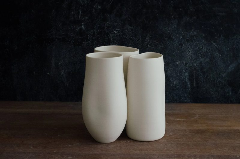 A pair of porcelain beakers on a dark table